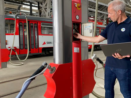 Mann mit Laptop in der Hand prüft eine Besandungsstation